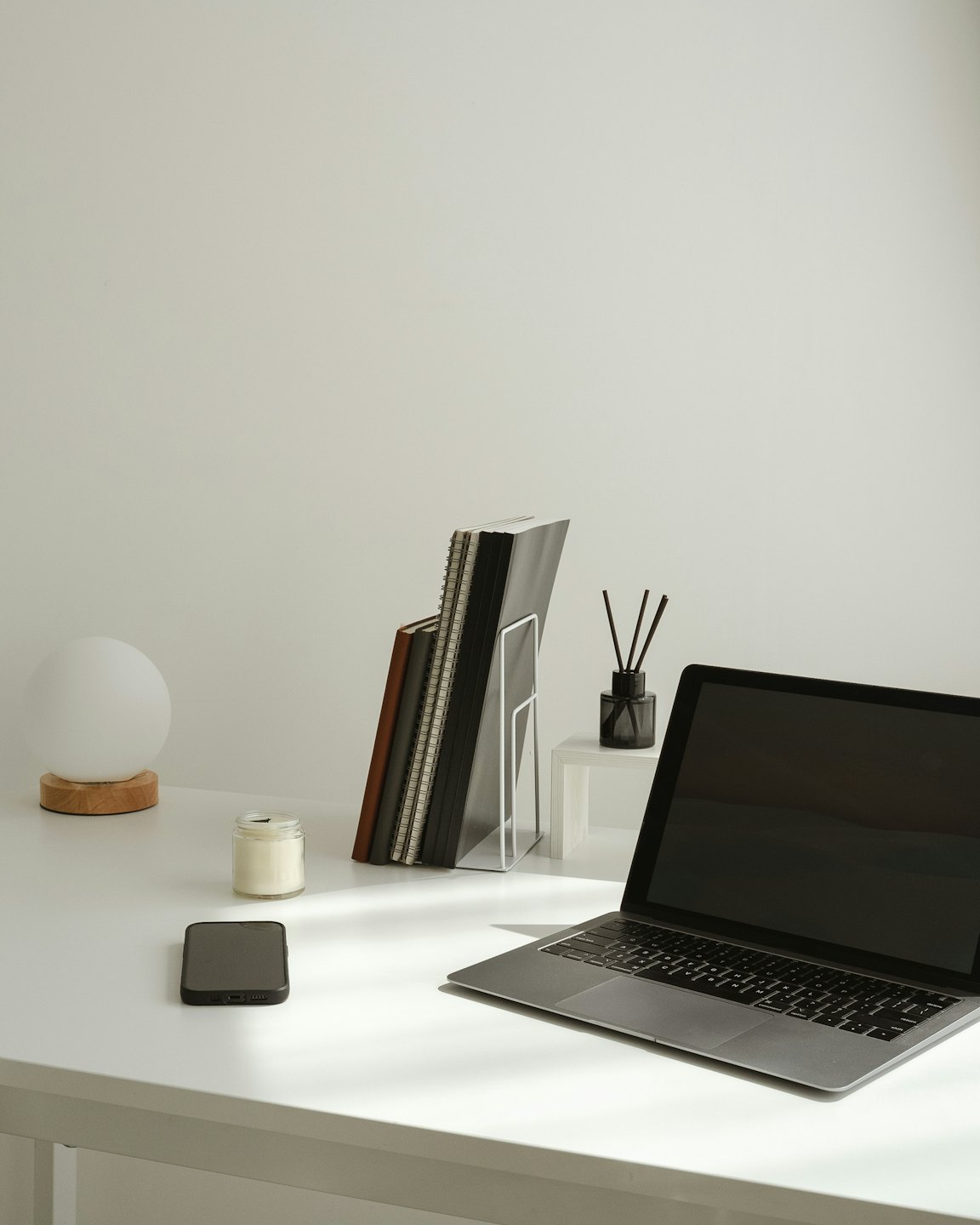 Ordinateur portable et accessoires de bureau joliment disposés sur un bureau en bois.